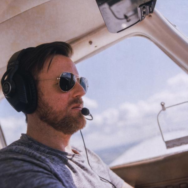 Middle aged man flying a light plane