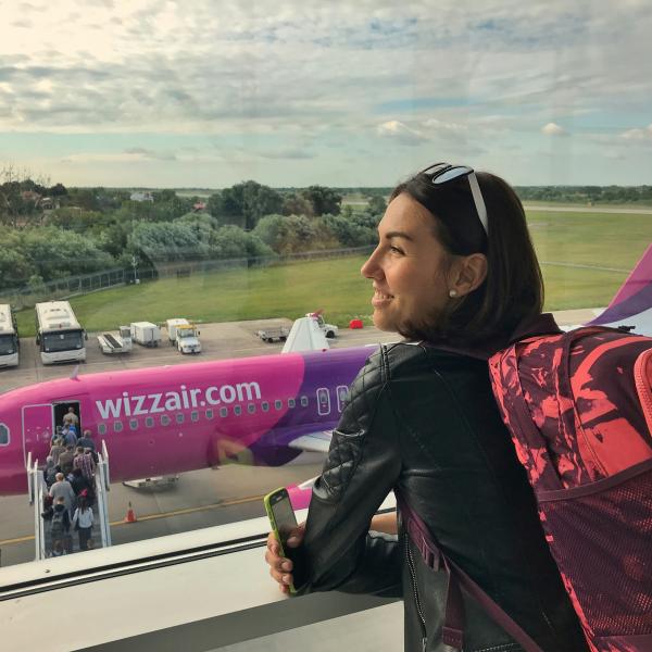 a girl at the airport looking at the airplane